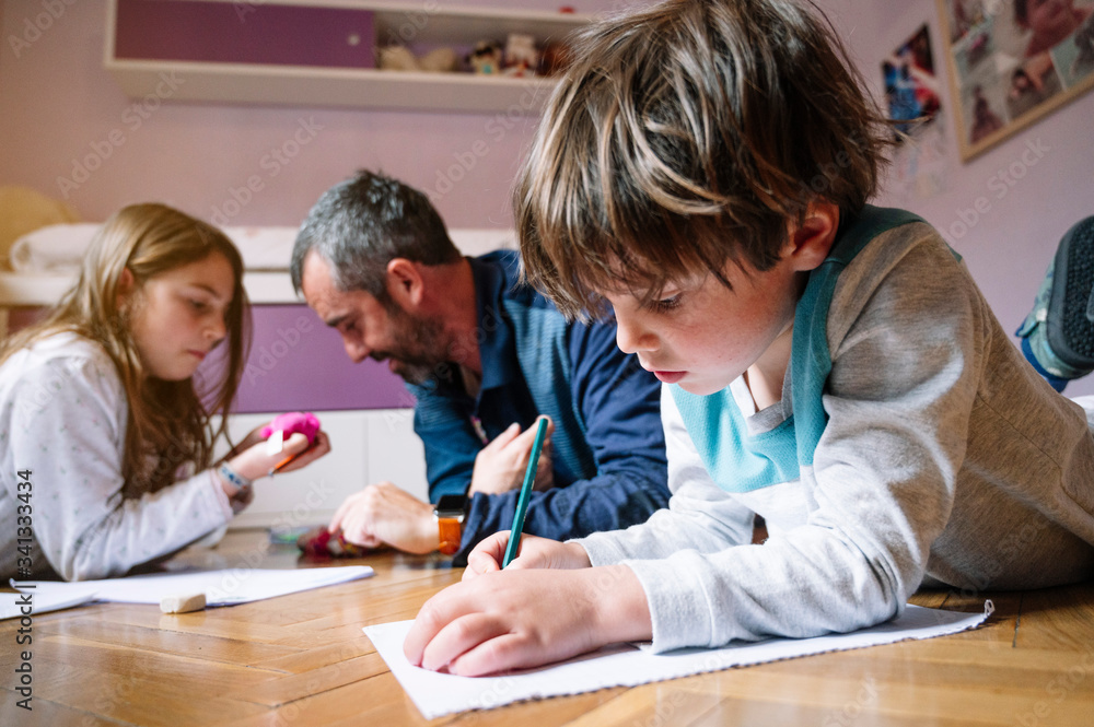 Children at home drawing with their parents Children at home drawing with their parents