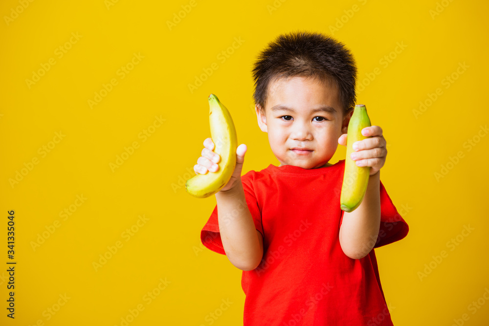 child or kid cute little boy attractive smile playing holds banana fruit child or kid cute little boy attractive smile playing holds banana fruit