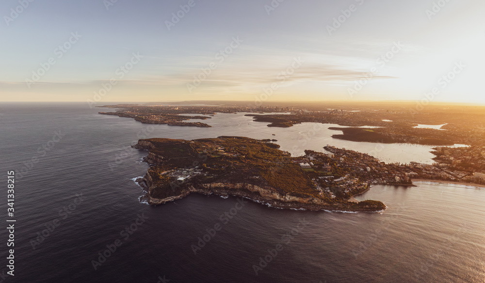 Obraz premium XXL panoramic sunset aerial drone view of North Head, a headland in Manly, Sydney, New South Wales, Australia. Manly Beach on right. Sydney Harbour with South Head, CBD & Harbour Bridge in background.