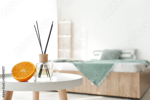 Reed diffuser on table in b...
