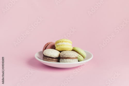 Tasty french macarons on a white plate.