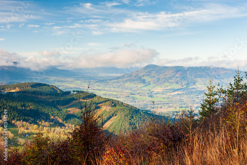 Sunrise in Beskydy mountains with fog in the valley and dramatic cloudy sky, beutiful sunny morning in Czech mountains, Beskid Slaski near Lysa hora mountain.