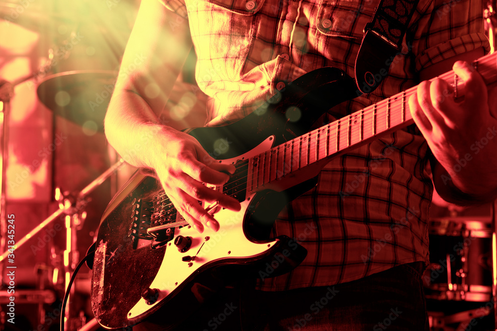 Obraz premium Life style image of close up young male guitarist hand, playing electric guitar