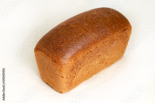 The grey loaf of rye bread. Closeup on a light background