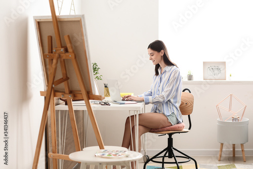 Young woman with laptop wor...