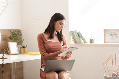 Focused young woman in glas...