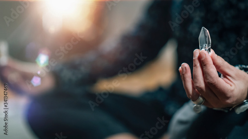 Woman Meditating with Quartz Crystal Chakra Wand in Hand