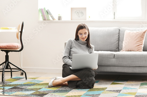 Young woman with laptop wor...