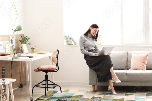 Young woman with laptop wor...