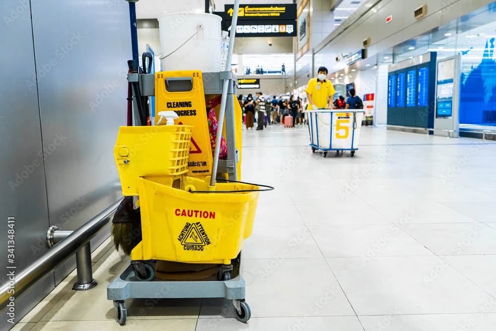 A set of tools and plates for mopping at the airport. Yellow bucket plates and brushes. Cleaning Service A set of tools and plates for mopping at the airport. Yellow bucket plates and brushes. Cleaning Service