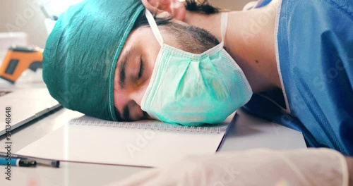 Medico sta dormendo sulla scrivania photo