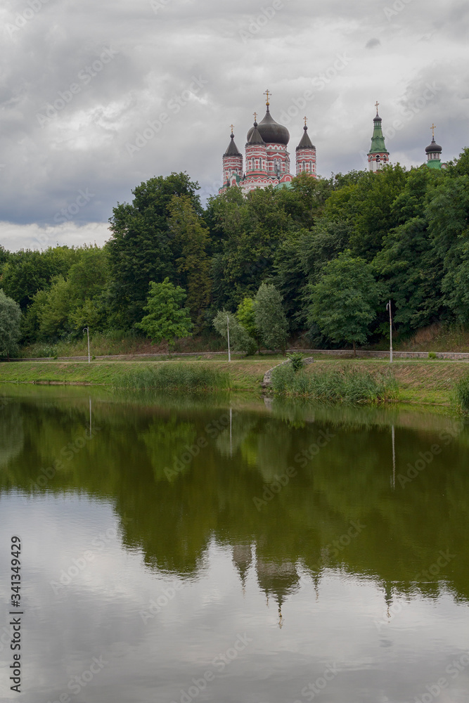 Domes of the monastery are reflected in the lake of Theophany Park. Kiev, Ukraine