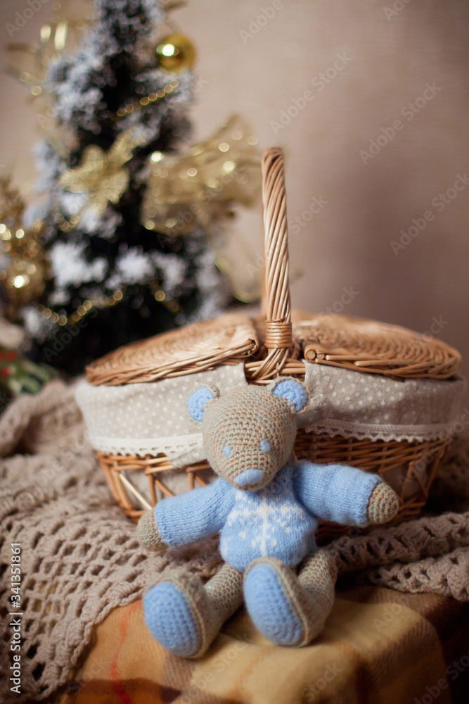 knitted toy bear or mouse sits near a wicker basket