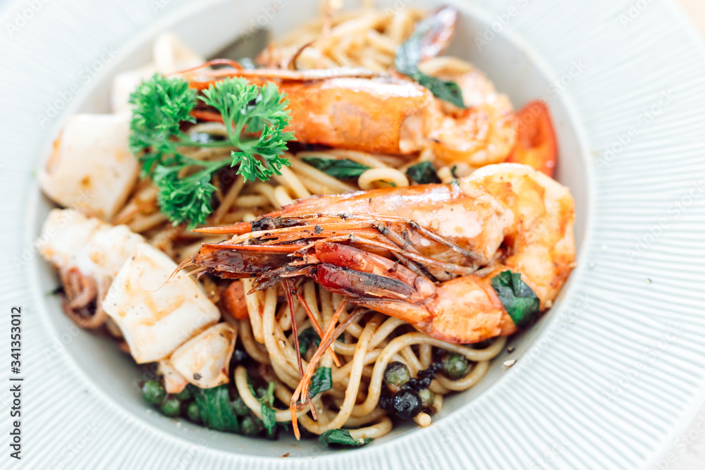 drunken spaghetti with seafood on white plate is modern Thai fusion food