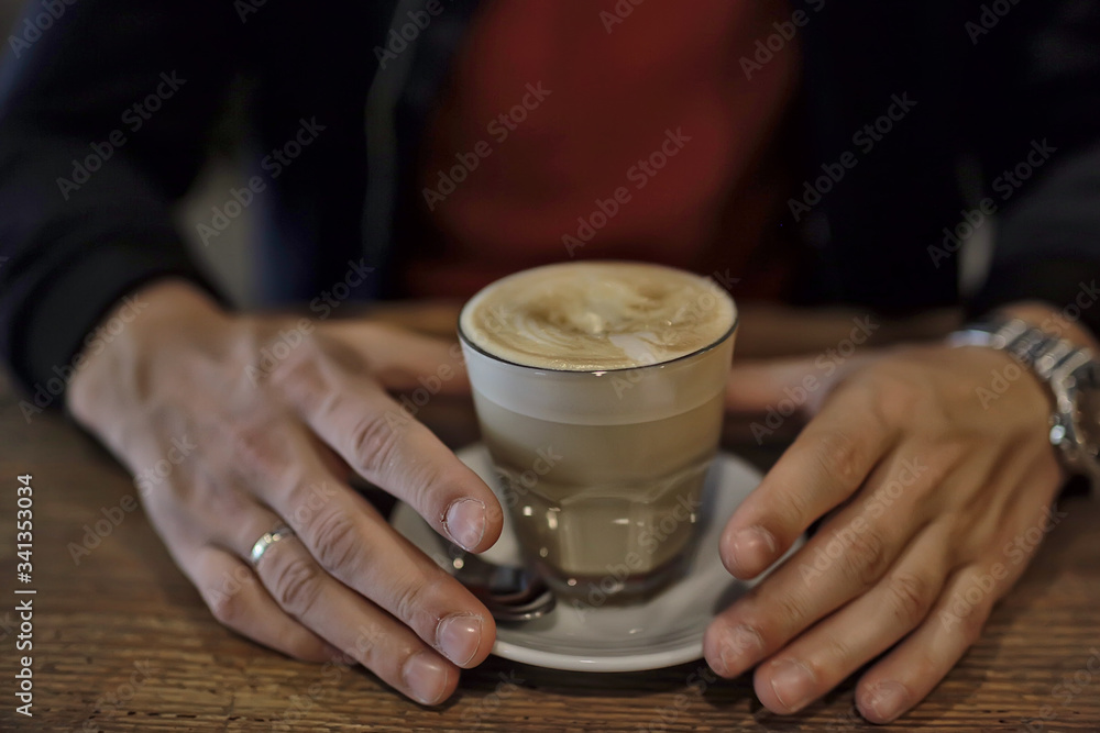 cup of cappuccino in a cafe in hands, coffee in a restaurant interior