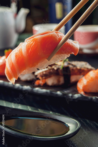 Close-up of salmon sushi with chopsticks and soy sauce