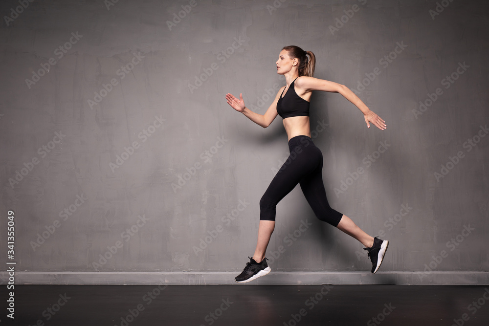 young woman doing exercise on grey background
