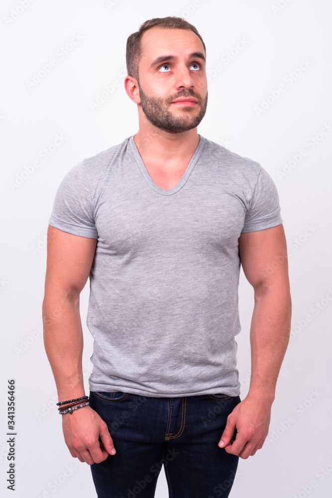 Fototapeta premium Portrait of muscular bearded man thinking and looking up