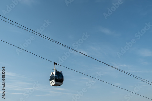 Cableway against the blue sky. Elegant cabs move along steel ropes. Day. Sunny. Georgia, Tbilisi.