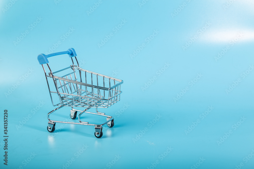 Empty Groceries trolley on blue background Empty Groceries trolley on blue background