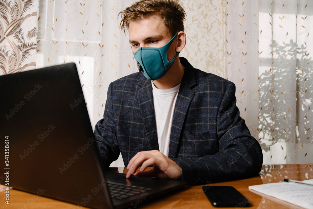 Man working from home with laptop computer and wearing face mask Man working from home with laptop computer and wearing face mask