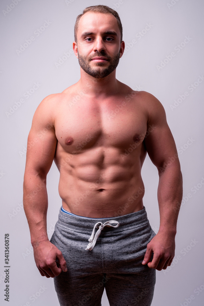 Portrait of muscular bearded man looking at camera shirtless