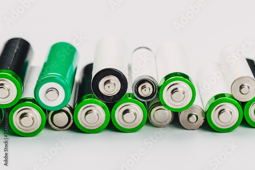 many new and used alkaline the positive ends of battery cells. type AA on a light background.