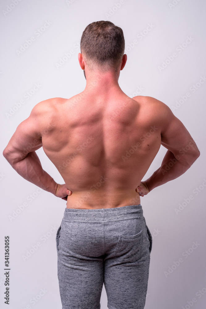 Rear view of muscular man showing back muscles shirtless