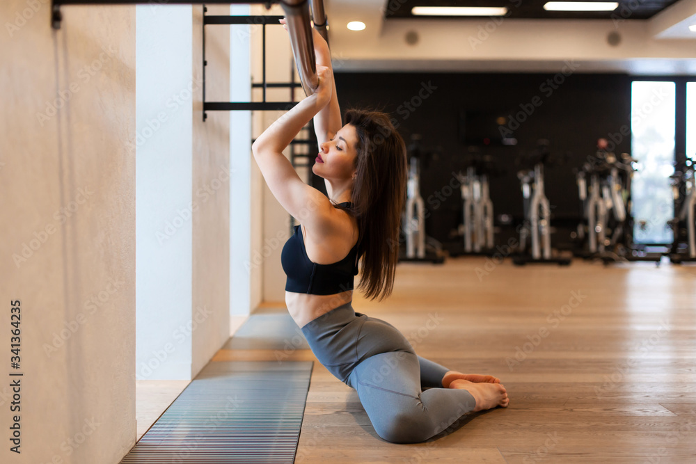 Young sexy woman doing stretching exercises in gym Young sexy woman doing stretching exercises in gym