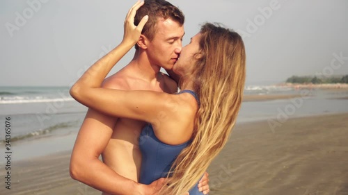 Newlyweds, a young couple in love kisses on the beach