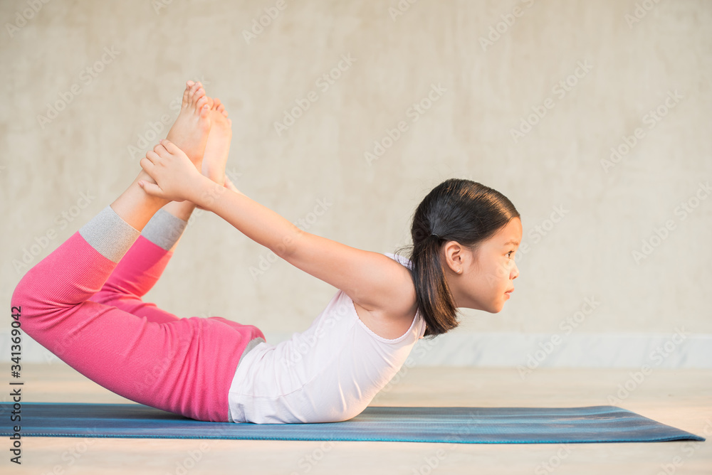 calmness and relax, female freedom happiness. home practice room background. little asian girl meditates while practicing yoga. child happiness. toned picture healthy life. yoga concept. calmness and relax, female freedom happiness. home practice room background. little asian girl meditates while practicing yoga. child happiness. toned picture healthy life. yoga concept.