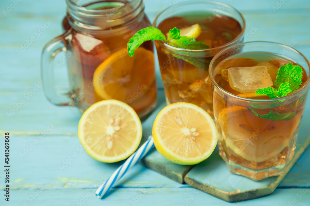 Iced tea with lemon slices and mint on wood background Iced tea with lemon slices and mint on wood background