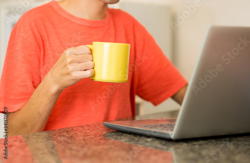 Using computer to shop online. Shopping Online. Studying at home. Using laptop with a coffee mug. Home office.
