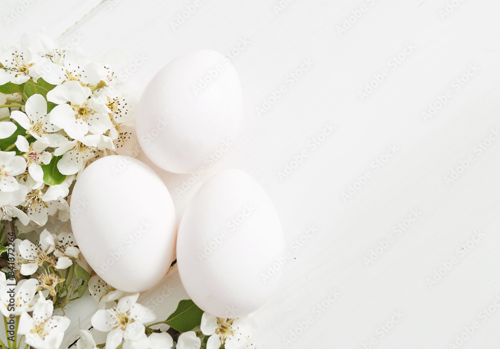 White Easter eggs and spring branch with flowers on wooden background. Spring easter greeting card.Flowers Cherry flowering.Spring flowers. Beautiful Orchard.Springtime