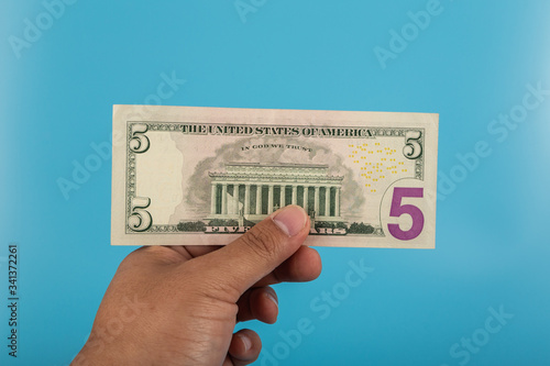 Man holding dollar bill US dollar banknote on blue background