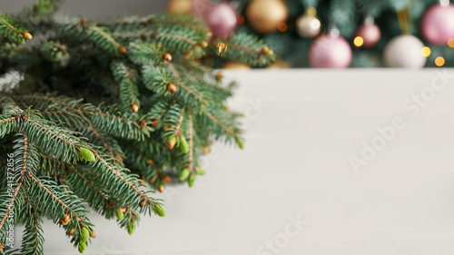 Christmas composition. Fir branches on wooden white background. Flat lay, top view, copy space. Christmas still life. Christmas frame made of fir branches and pink toys. Greeting card. Happy New Year