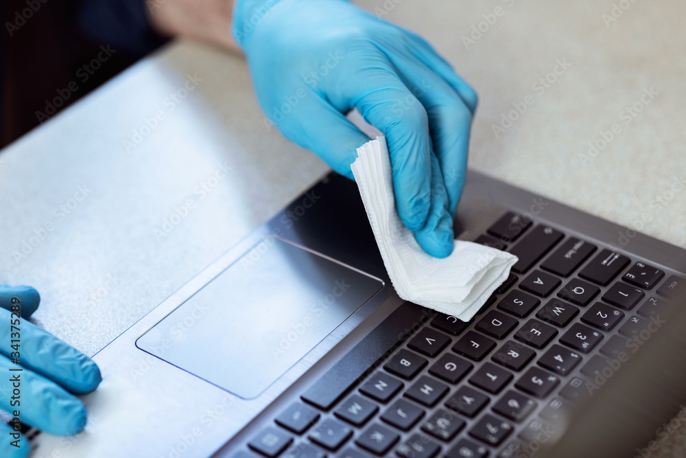 Male Hands In Gloves Disinfecting Laptop Before Work At Home Male Hands In Gloves Disinfecting Laptop Before Work At Home