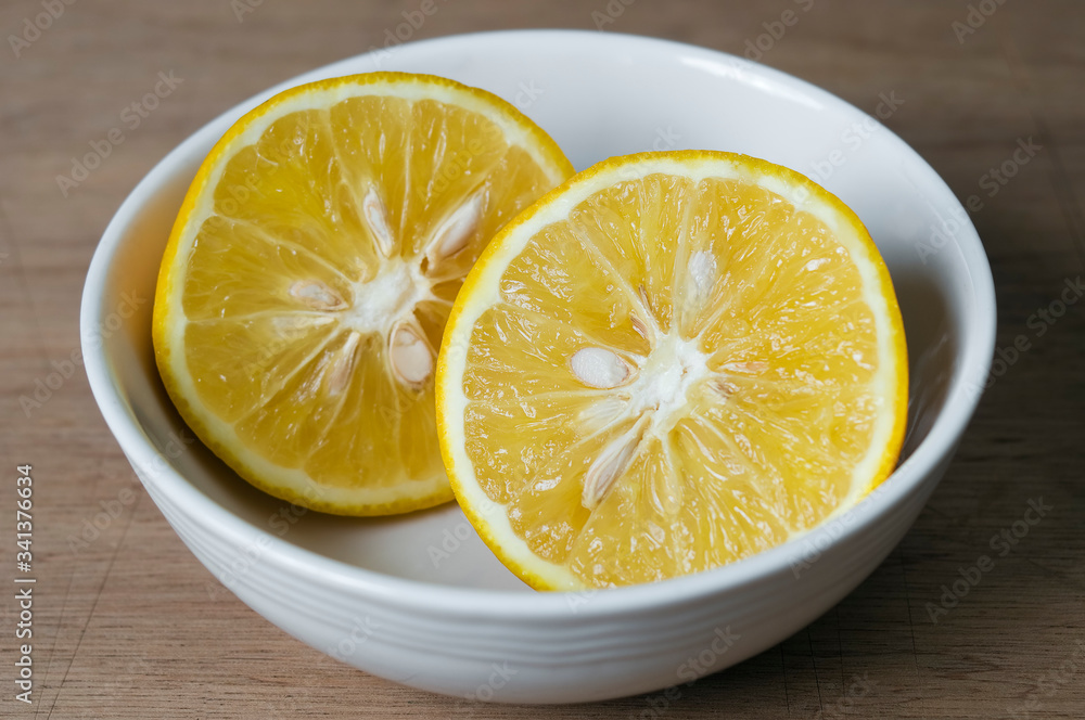 A sliced orange served in a bowl on a tabletop. A sliced orange served in a bowl on a tabletop.