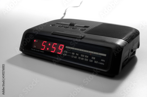 A radio alarm clock with an early hour on it's display over a white background.