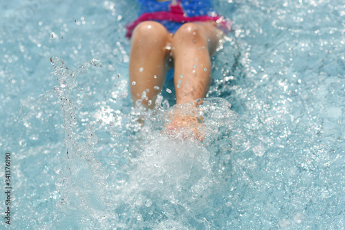 Kid's leg splashing water in the pool, summer holiday © ltyuan