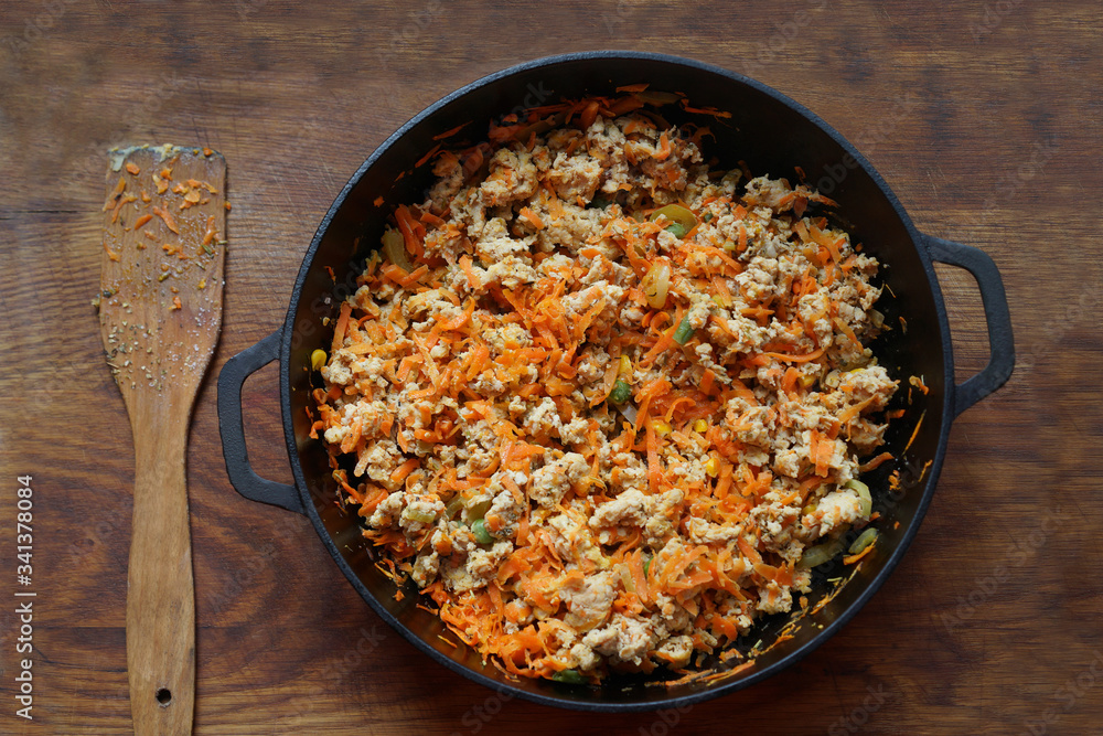 Cooking at home kitchen chicken meat side dish. Cook fry minced meat with vegetables. Cooking at home kitchen chicken meat side dish. Cook fry minced meat with vegetables.