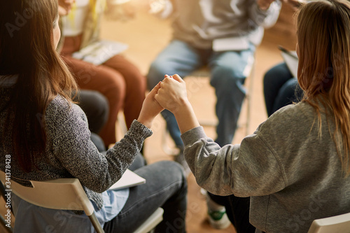 Bilde på lerret cropped club members sit in the circle, hold hands of each other, pray for the b