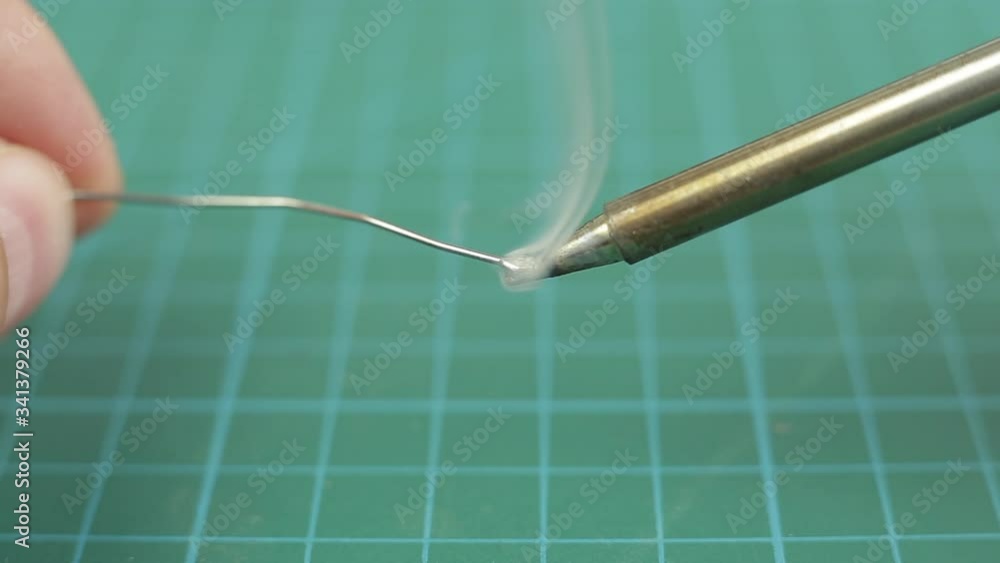 Melted solder wire over a hot soldering iron tip. Close up. Melted solder wire over a hot soldering iron tip. Close up.