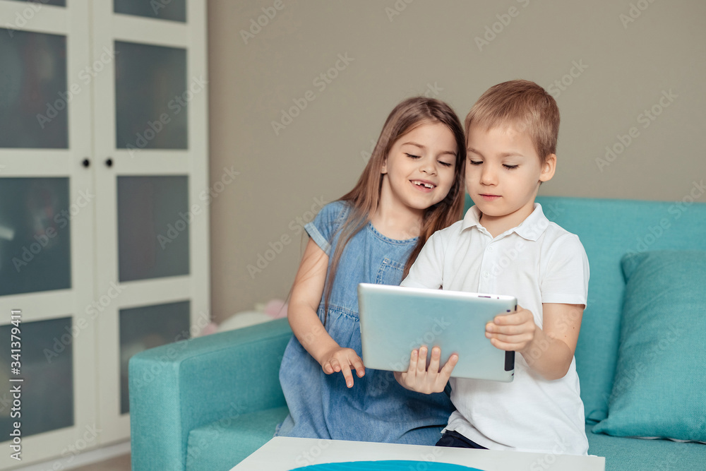 home distance learning at home. twins brother and sister study at home using tablet home distance learning at home. twins brother and sister study at home using tablet
