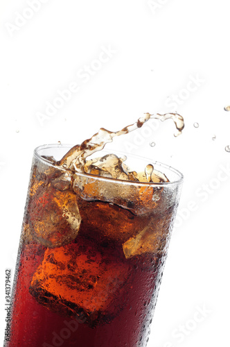 A tall glass with ice and refreshing cola like colored drink.