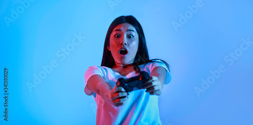Real game. Surprised young woman with gamepad