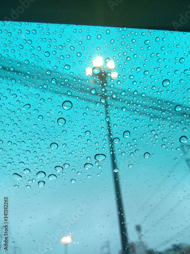 Raining, water droplets dripping on the windshield.