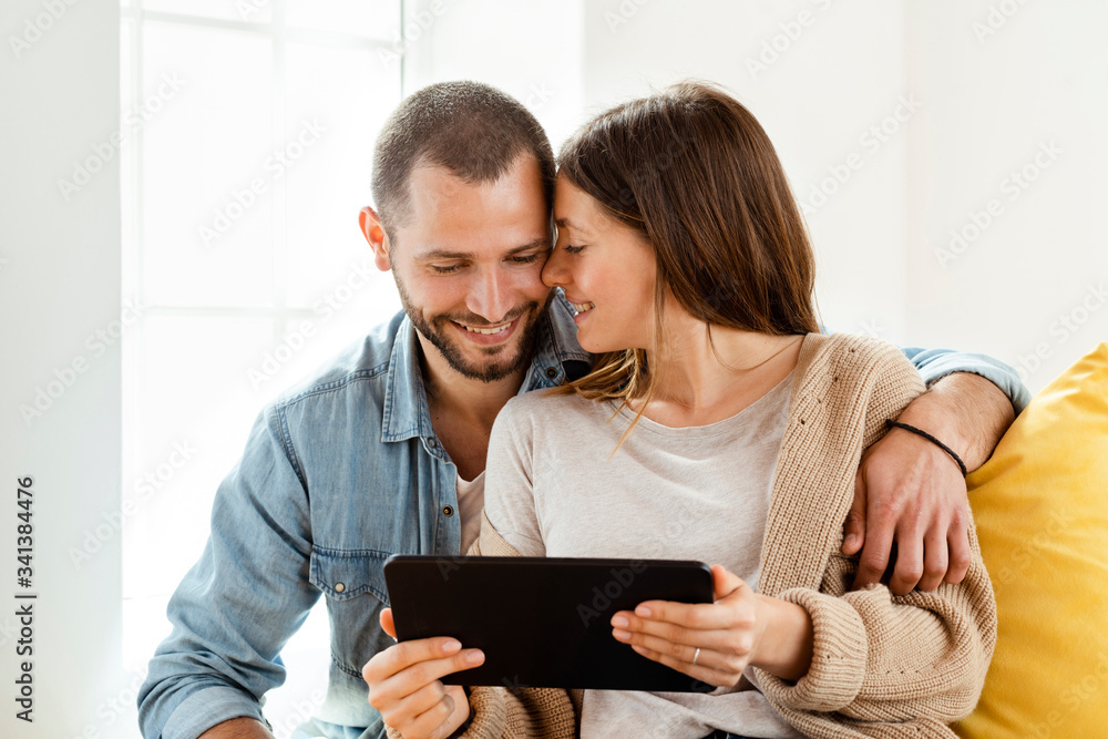 Happy affectionate couple with tablet at home Happy affectionate couple with tablet at home