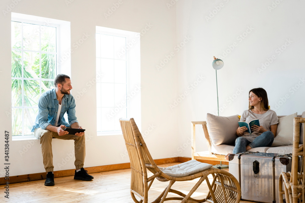 Couple talking to each other at home in living room Couple talking to each other at home in living room