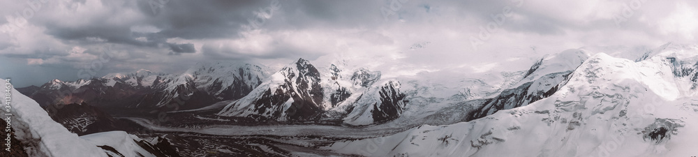 Pamir. Peak of Lenin. Kyrgyzstan. Pan-frame photo. High mountains covered in snow. storm clouds